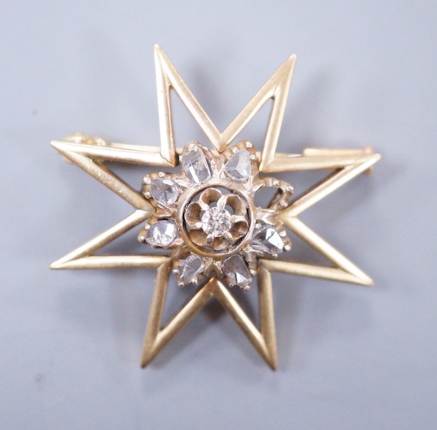 A yellow metal and diamond cluster set star brooch, 30mm, gross weight 6.6 grams.